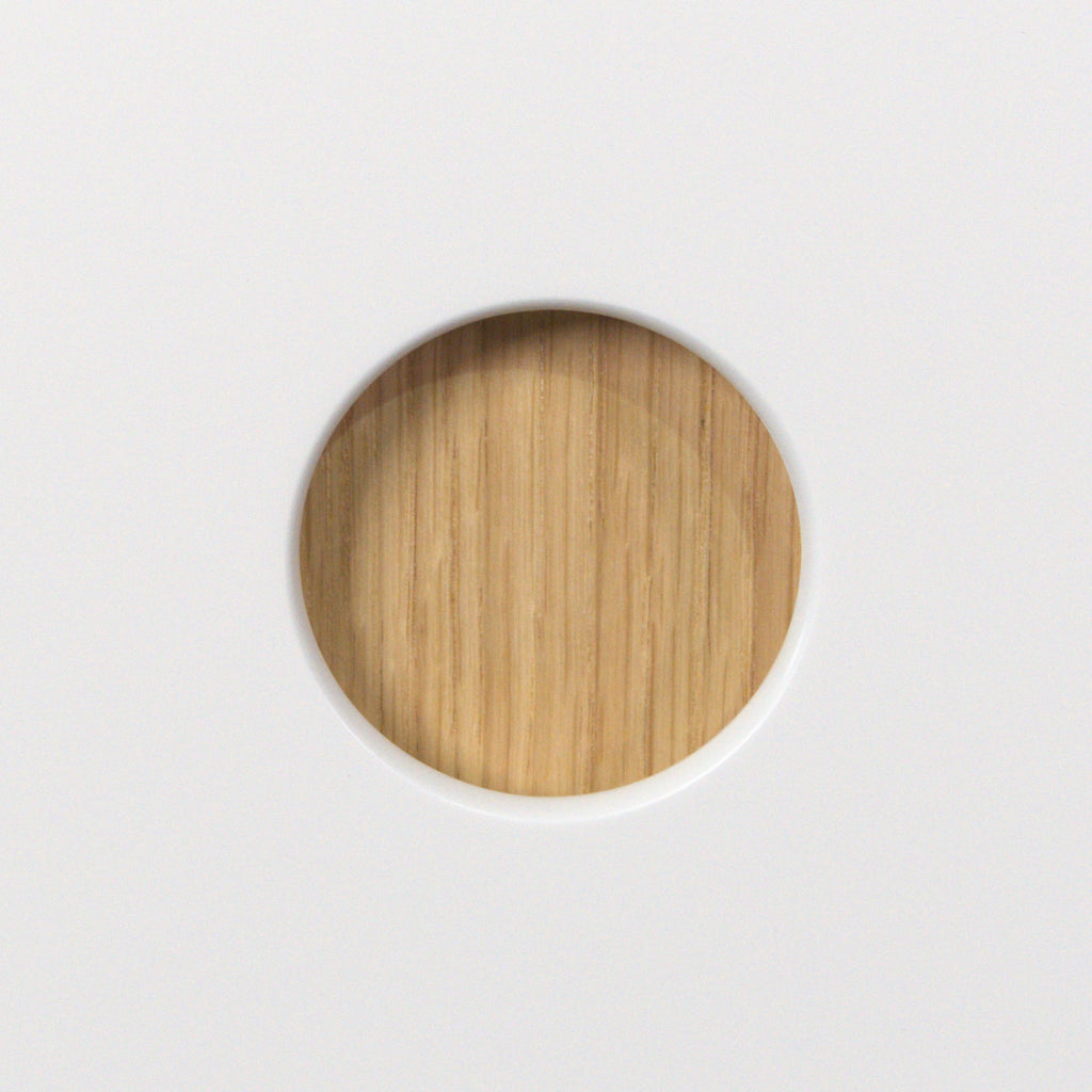 Okrągły otwór-uchwyt Ø50 mm z wnętrzem z forniru dębowego w białym froncie Round Oak, zbliżenie